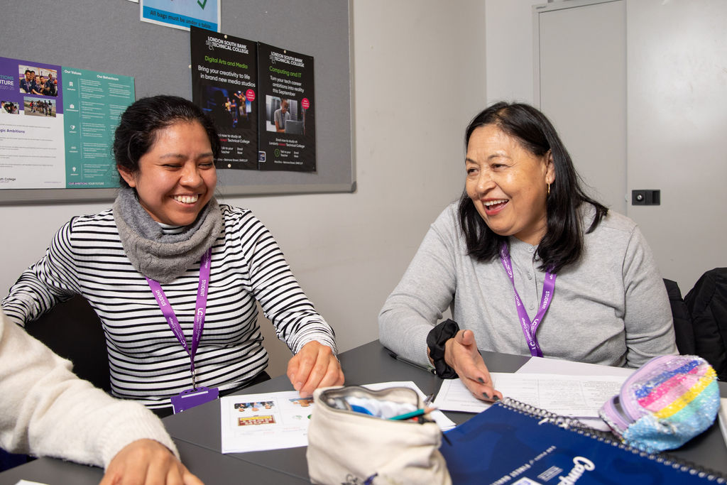 Two Lambeth College students, posing and smiling to each other